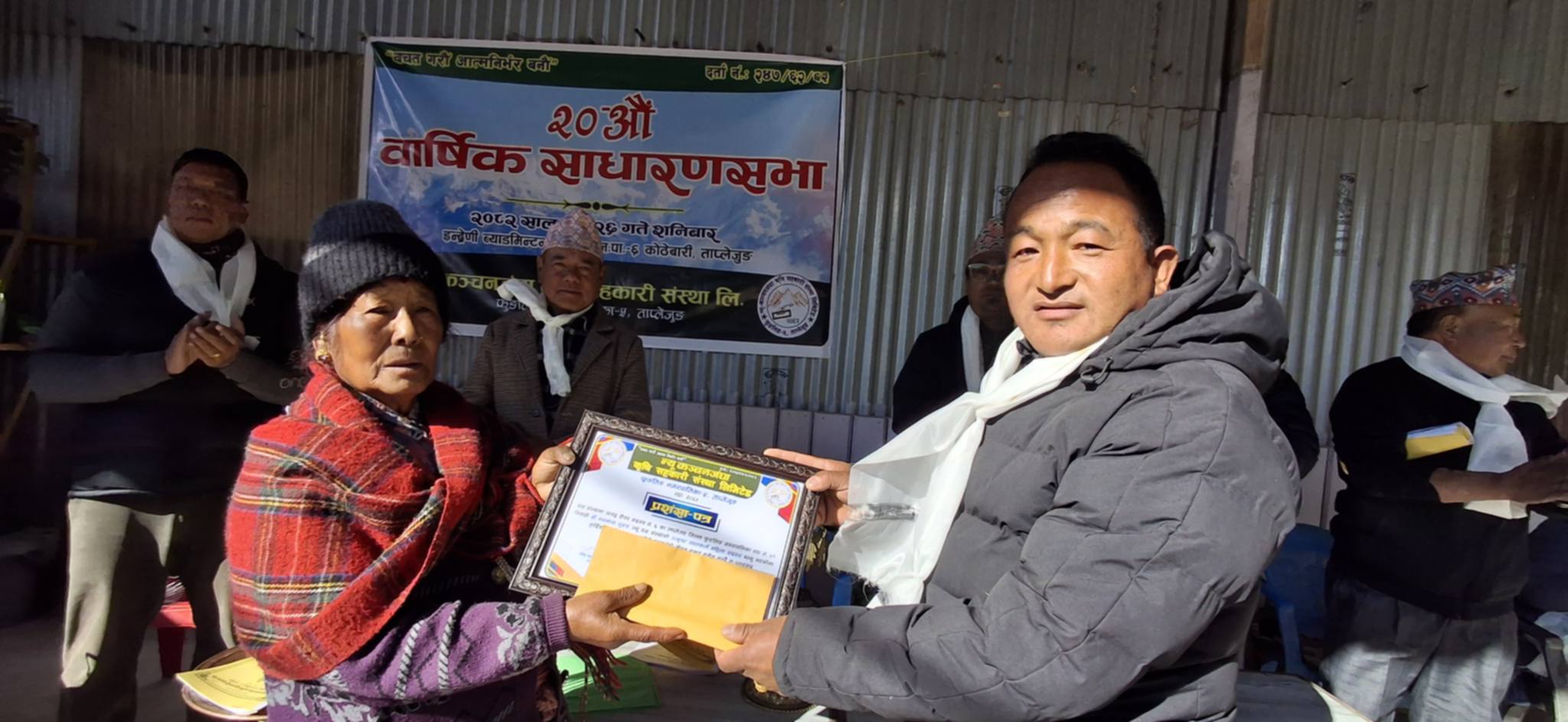 विशिष्ट अतिथि वडाअध्यक्ष तेज गुरुङमार्फत नियमित बचत गरेर पुरस्कृत भएका मनमाया गुरुङको सम्मान पत्र ग्रहण गर्दै छिमेकी कमलादेवी गुरुङ&nbsp;